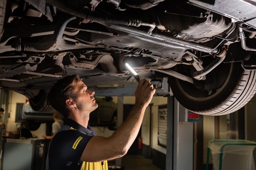 monteur onder auto met zaklamp